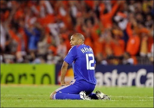 French striker Thierry Henry is disconsolate but Dutch fans behind him celebrate wildly
